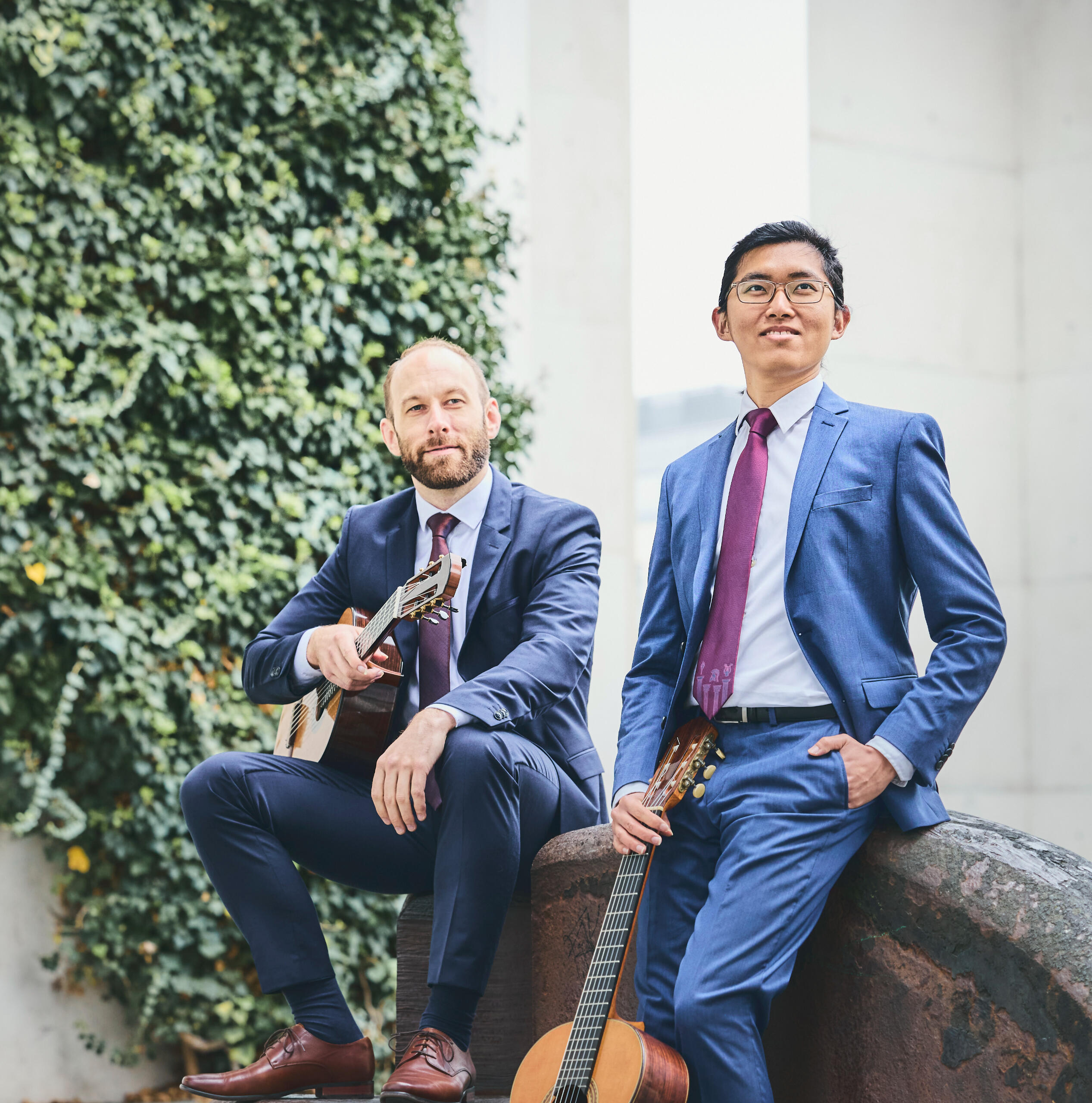 Two person posing with classical guitars